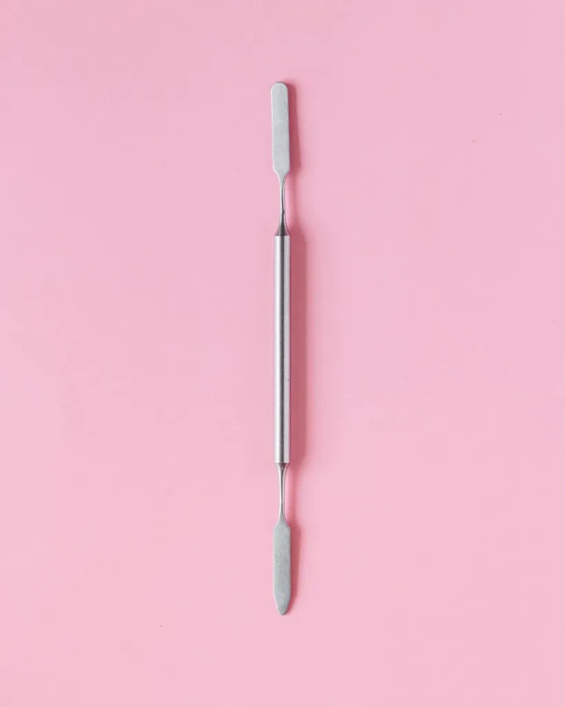 Herramienta de lifting de acero sobre fondo rosa