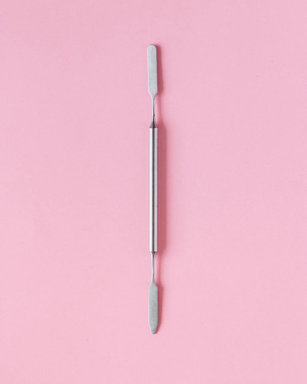 Herramienta de lifting de acero sobre fondo rosa