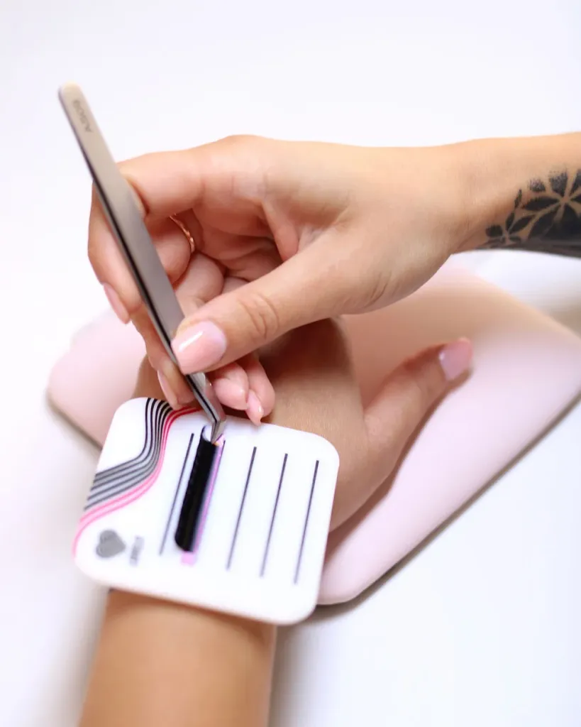 Paleta para pestañas sujeta a la mano, con una tira de pestañas
