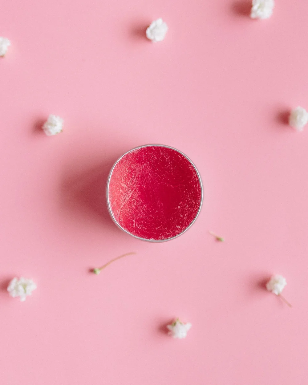 Tarro de removedor en crema sobre fondo rosa
